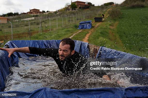 Competitor slips as he crosses a water container during the first Belik Race on April 19, 2015 in Cabanillas del Campo, in the region of Guadalajara,...