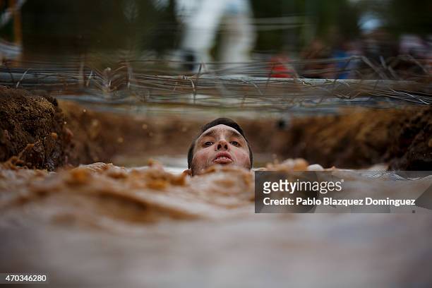 Competitor passes under a fence through the water during the first Belik Race on April 19, 2015 in Cabanillas del Campo, in the region of...