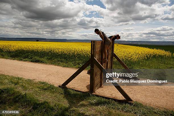 Competitors climb over a wooden wall during the first Belik Race on April 19, 2015 in Cabanillas del Campo, in the region of Guadalajara, Spain.