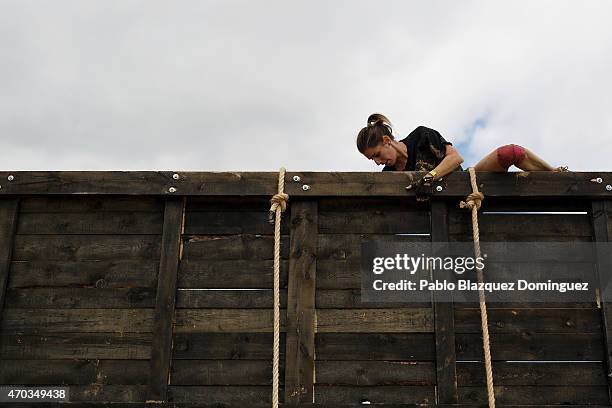 Competitor climbs over a wooden wall during the first Belik Race on April 19, 2015 in Cabanillas del Campo, in the region of Guadalajara, Spain.