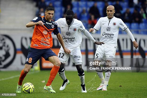 Montpellier's French midfielder Jonas Martin vies with Caen's French defenders Dennis Appiah and Alaeddine Yahia during the French L1 football match...