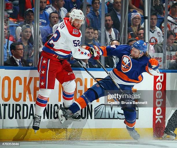 Calvin de Haan of the New York Islanders checks Mike Green of the Washington Capitals during the first period in Game Three of the Eastern Conference...