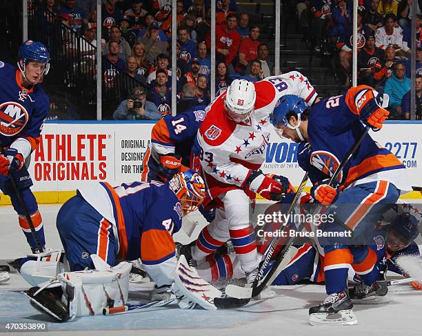 Jay Beagle of the Washington Capitals looks for the rebound as the puck bounces off the leg pad of Jaroslav Halak of the New York Islanders during...