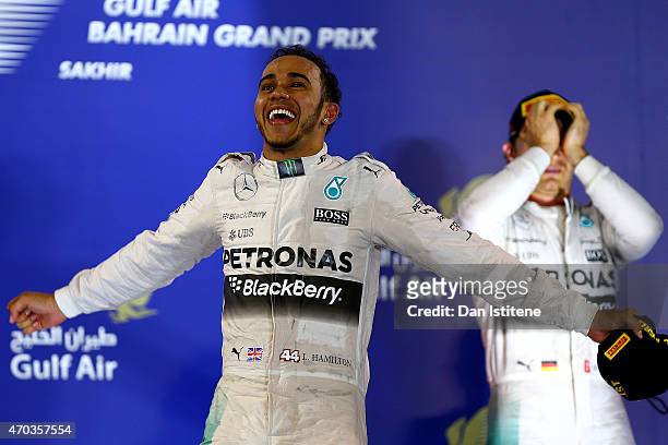 Lewis Hamilton of Great Britain and Mercedes GP celebrates next to Nico Rosberg of Germany and Mercedes GP on the podium after winning the Bahrain...
