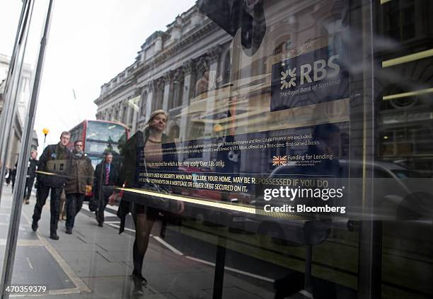 Logo sits on a poster inside the window of a Royal Bank of Scotland Group Plc bank branch in London, U.K., on Wednesday, Feb. 19, 2014. Royal Bank of...