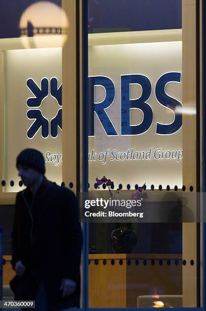 An illuminated logo sits behind the reception desk inside the Royal Bank of Scotland Group Plc's headquarters in London, U.K., on Wednesday, Feb. 19,...