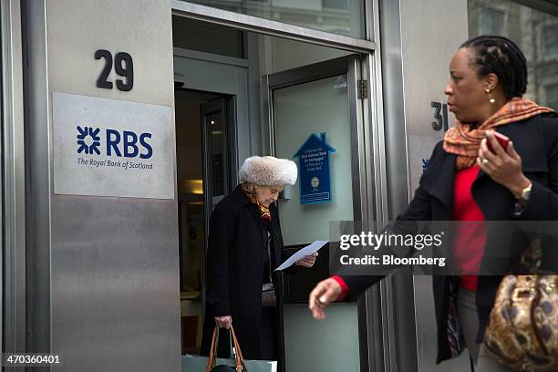 Customer exits a Royal Bank of Scotland Group Plc bank branch in London, U.K., on Wednesday, Feb. 19, 2014. Royal Bank of Scotland Group suspended a...
