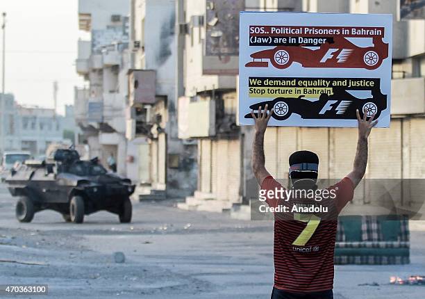 Protester holds a placard demanding the cancellation of Formula 1 races which is being held in Manama as they stage an anti-government demonstration...