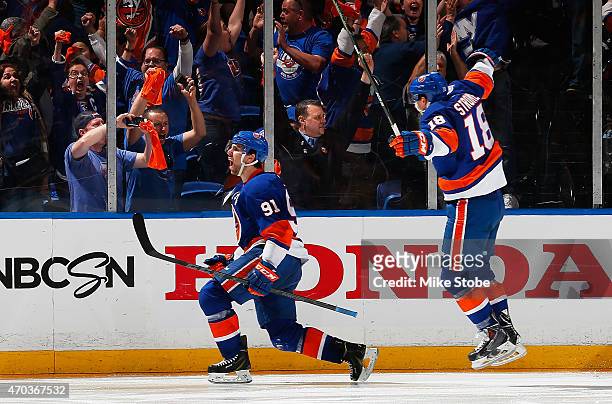 John Tavares of the New York Islanders celebrates his game winning goal in overtime with teammate Ryan Strome during the game against the Washington...