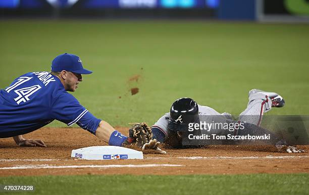 Justin Smoak of the Toronto Blue Jays tags out Cameron Maybin of the Atlanta Braves as he tries to dive back to first base to complete a double play...