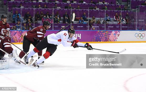 Rick Nash of Canada lunges for the puck against Lauris Darzins of Latvia during the Men's Ice Hockey Quarterfinal Playoff on Day 12 of the 2014 Sochi...