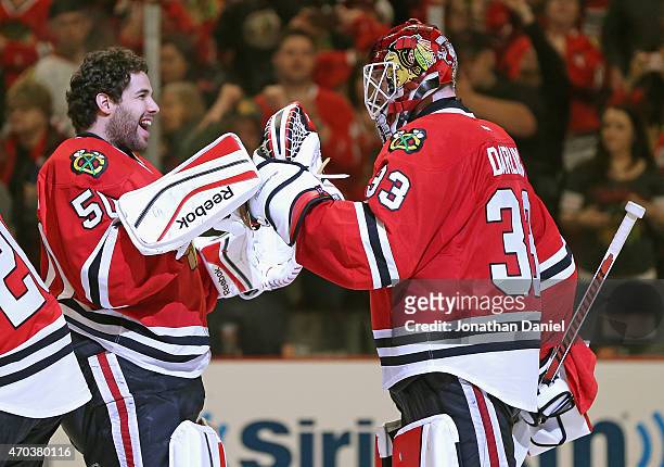 Corey Crawford of the Chicago Blackhawks congratulates Scott Darling after a win over the Nashville Predators in Game Three of the Western Conference...
