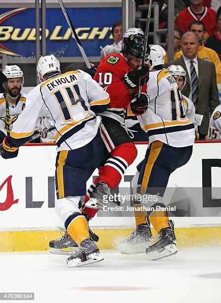 Patrick Sharp of the Chicago Blackhawks collides with Mattias Ekholm and James Neal of the Nashville Predators in Game Three of the Western...