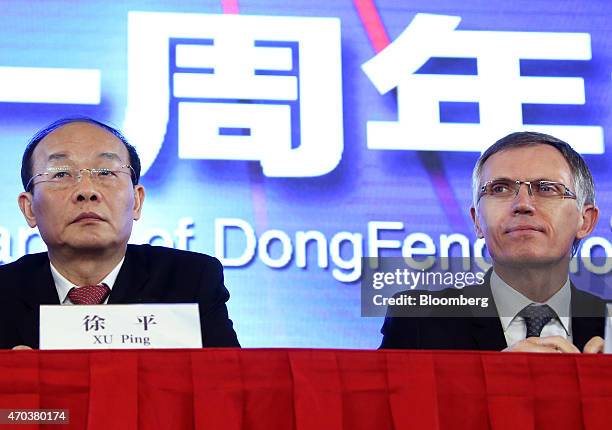 Carlos Tavares, chief executive officer of PSA Peugeot Citroen, right, and Xu Ping, chairman of Dongfeng Motor Group Co., left, attend a joint news...