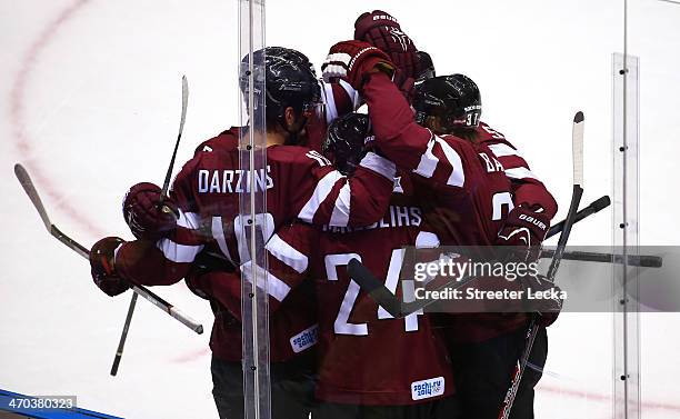Lauris Darzins of Latvia celebrates with teammates after scoring a first-period goal against Canada during the Men's Ice Hockey Quarterfinal Playoff...