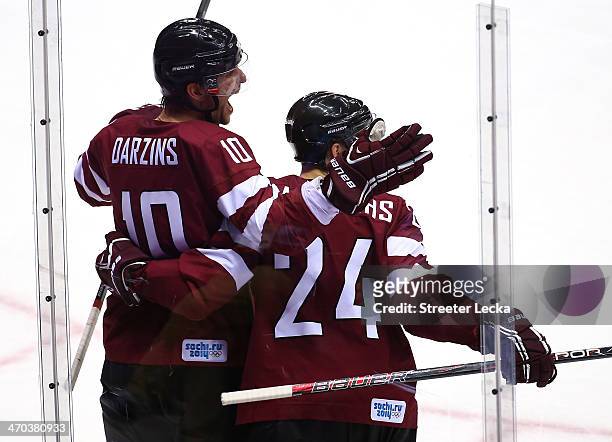 Lauris Darzins of Latvia celebrates with teammates after scoring a first-period goal against Canada during the Men's Ice Hockey Quarterfinal Playoff...