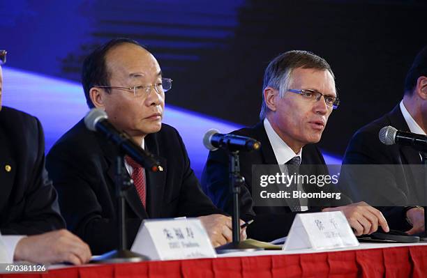 Carlos Tavares, chief executive officer of PSA Peugeot Citroen, right, and Xu Ping, chairman of Dongfeng Motor Group Co., left, attend a joint news...