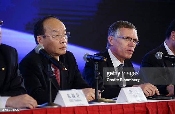 Carlos Tavares, chief executive officer of PSA Peugeot Citroen, right, and Xu Ping, chairman of Dongfeng Motor Group Co., left, attend a joint news...