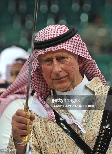 Britain's Prince Charles, wearing traditional Saudi uniform, dances with sword during the traditional Saudi dancing best known as 'Arda' performed...