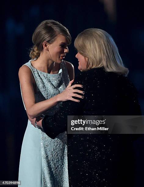 Honoree Taylor Swift accepts the 50th Anniversary Milestone Award for Youngest ACM Entertainer of the Year from her mother Andrea Finlay onstage...