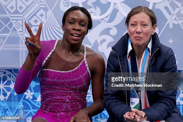 Mae Berenice Meite of France waits for her score with her coach Katia Krier Beyer in the Figure Skating Ladies' Short Program on day 12 of the Sochi...