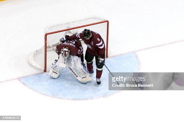 Sandis Ozolins of Latvia and Kristers Gudlevskis of Latvia react during the Men's Ice Hockey Quarterfinal Playoff against Canada on Day 12 of the...