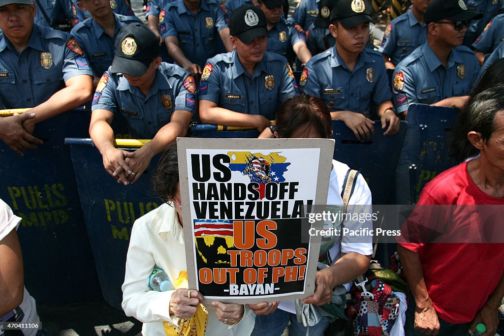 Protesters hold a poster against the the U.S. government  in...