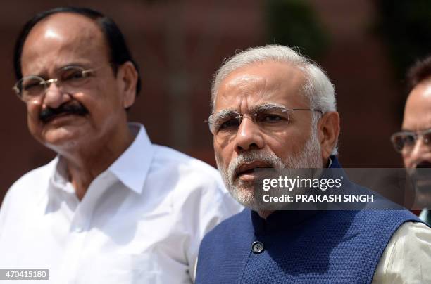 Indian Prime Minister Narendra Modi speaks to the media as Minister of Parliamentary Affairs Venkaiah Naidu looks on outside Parliament in New Delhi...