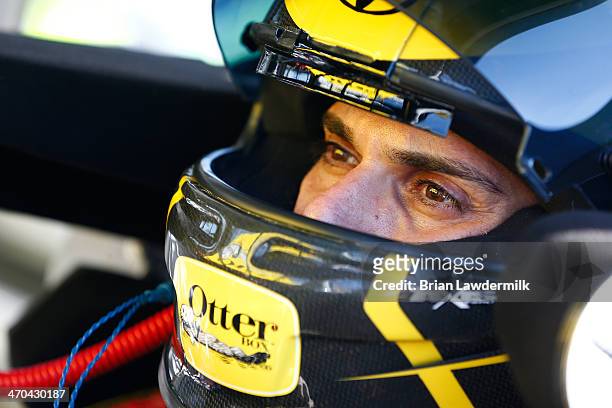 German Quiroga, driver of the OtterBox Toyota, sits in his truck in the garage during practice for the NASCAR Camping World Truck Series NextEra...