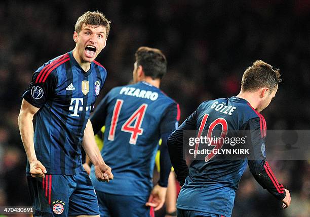 Bayern Munich's midfielder Thomas Mueller celebrates after scoring his team's second goal during the UEFA Champions League Last 16, first leg...