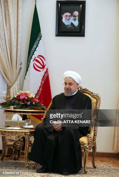 Iranian President Hassan Rouhani sits under portraits of Iran's supreme leader, Ayatollah Ali Khamenei and Iran's founder of Islamic Republic,...