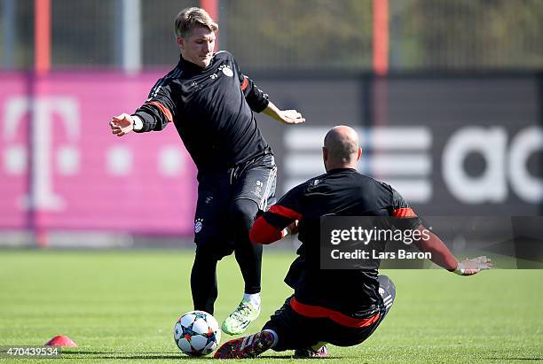 Bastian Schweinsteiger is challenged by Pepe Reina during a FC Bayern Muenchen training session prior to their UEFA Champions League Quarter Final...