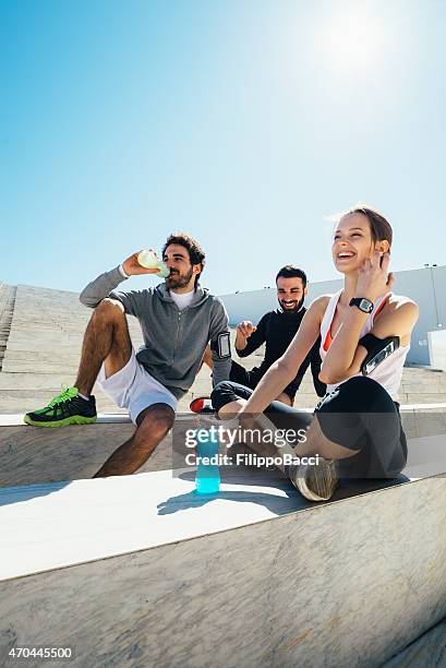 group having a break from exercise and having drinks - sports drink stock pictures, royalty-free photos & images