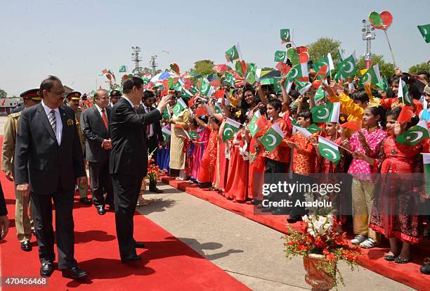 Handout picture released by the Press Information Department shows Chinese President Xi Jinping waving to Pakistani children as his Pakistani...