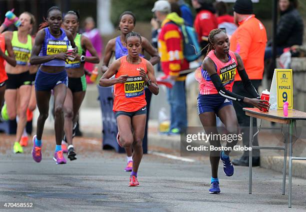 Caroline Kilel picks up fluid in Wellesley during the 2015 Boston Marathon.