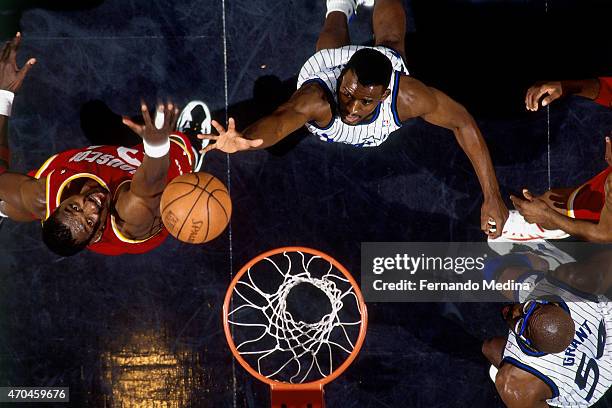 Anthony Bowie of the Orlando Magic goes after a rebound against Hakeem Olajuwon of the Houston Rockets on June 9, 1995 at the Orlando Arena in...