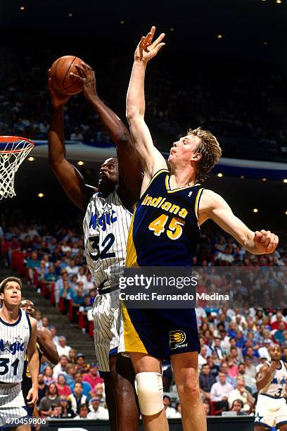 Shaquille O'Neal of the Orlando Magic goes up for a dunk against Rik Smits of the Indiana Pacers during game 1 of the Eastern Conference Finals on...