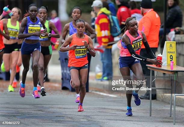 Caroline Kilel picks up fluid in Wellesley during the 2015 Boston Marathon.
