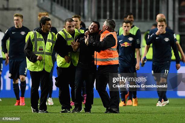 Spectator invades the pitch offending RB Leipzig players after the Second Bundesliga match between 1. FC Kaiserslautern and RB Leipzig at...