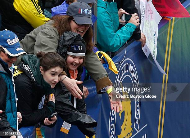 Denise Richard and her daughter Jane cheer on a team MR8 runner as they cross the Boston Marathon finish line on April 20, 2015.