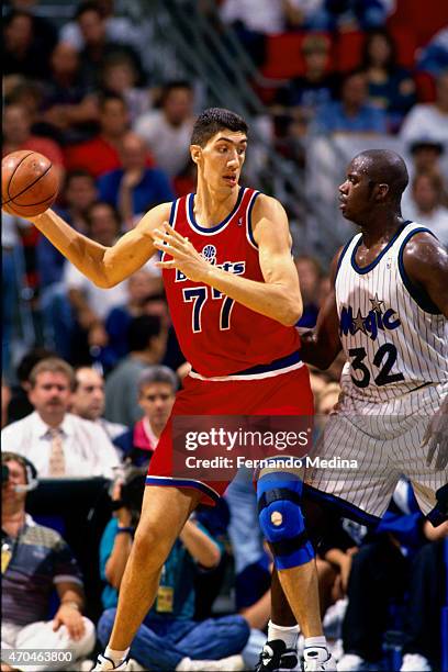 Gheorghe Muresan of the Washington Bullets handles the ball against Shaquille O'Neal of the Orlando Magic on October 15, 1994 at the Amway Arena in...