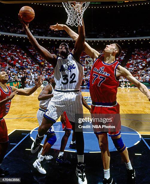 Shaquille O'Neal of the Orlando Magic shoots against Gheorghe Muresan of the Washington Bullets on April 17, 1995 at the Amway Arena in Orlando,...