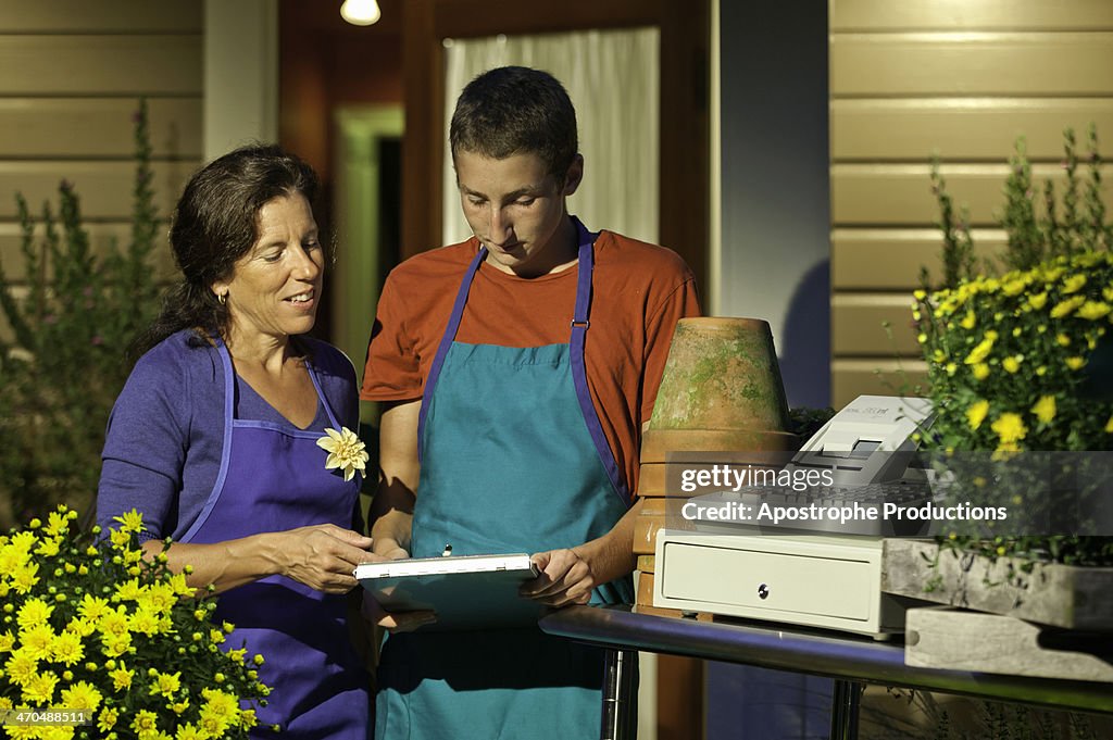 Teenage worker getting instructions at florist.