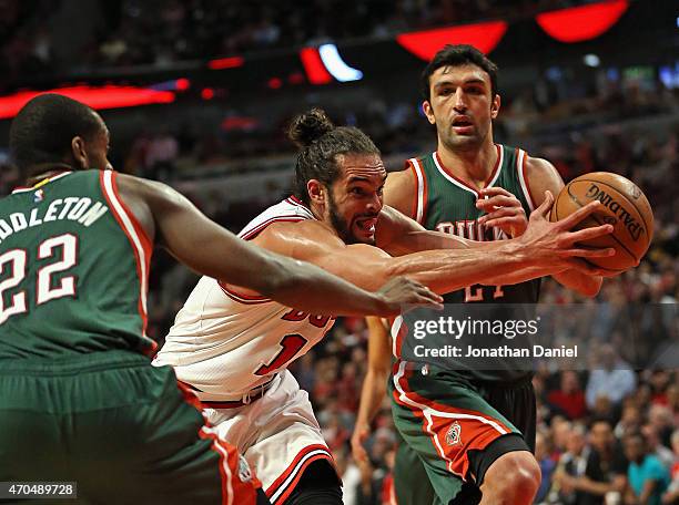 Joakim Noah of the Chicago Bulls drives between Khris Middleton and Zaza Pachulia of the Milwaukee Bucks during the first round of the 2015 NBA...