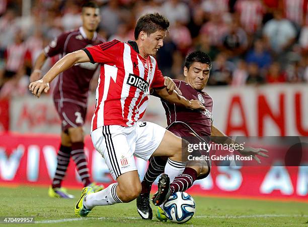 Guido Carrillo of Estudiantes fights for the ball with Paolo Goltz of Lanus during a match between Estudiantes and Lanus as part of third round of...