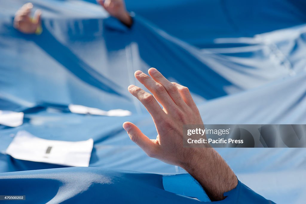 A hand is seen against a blue background; representing the...