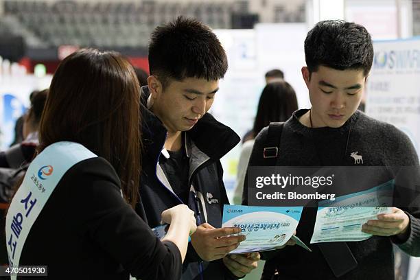 Jobseekers look at information booklets at a job fair in Goyang, South Korea, on Tuesday, April 21, 2015. South Korea is scheduled to release gross...