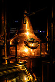 Copper metal vat in a dark distillery