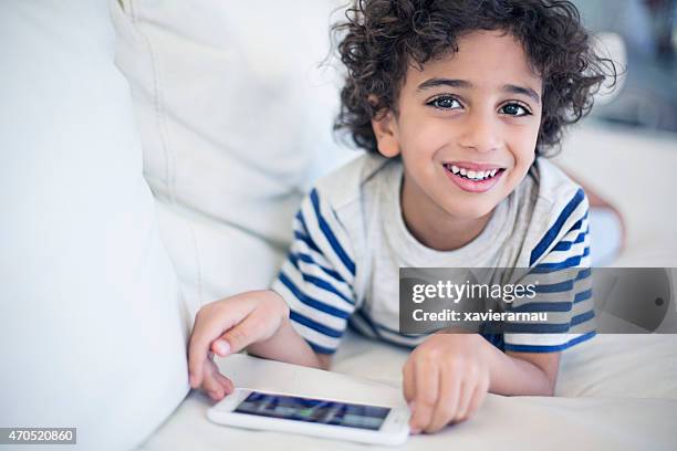 happy kid playing with the mobile phone - emirati youth stock pictures, royalty-free photos & images