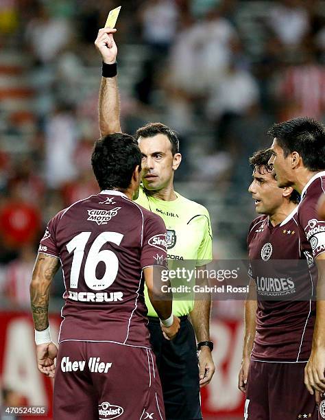 The referee Jorge Baliño shows a yellow card to Victor Ayala of Lanus during a match between Estudiantes and Lanus as part of third round of Torneo...